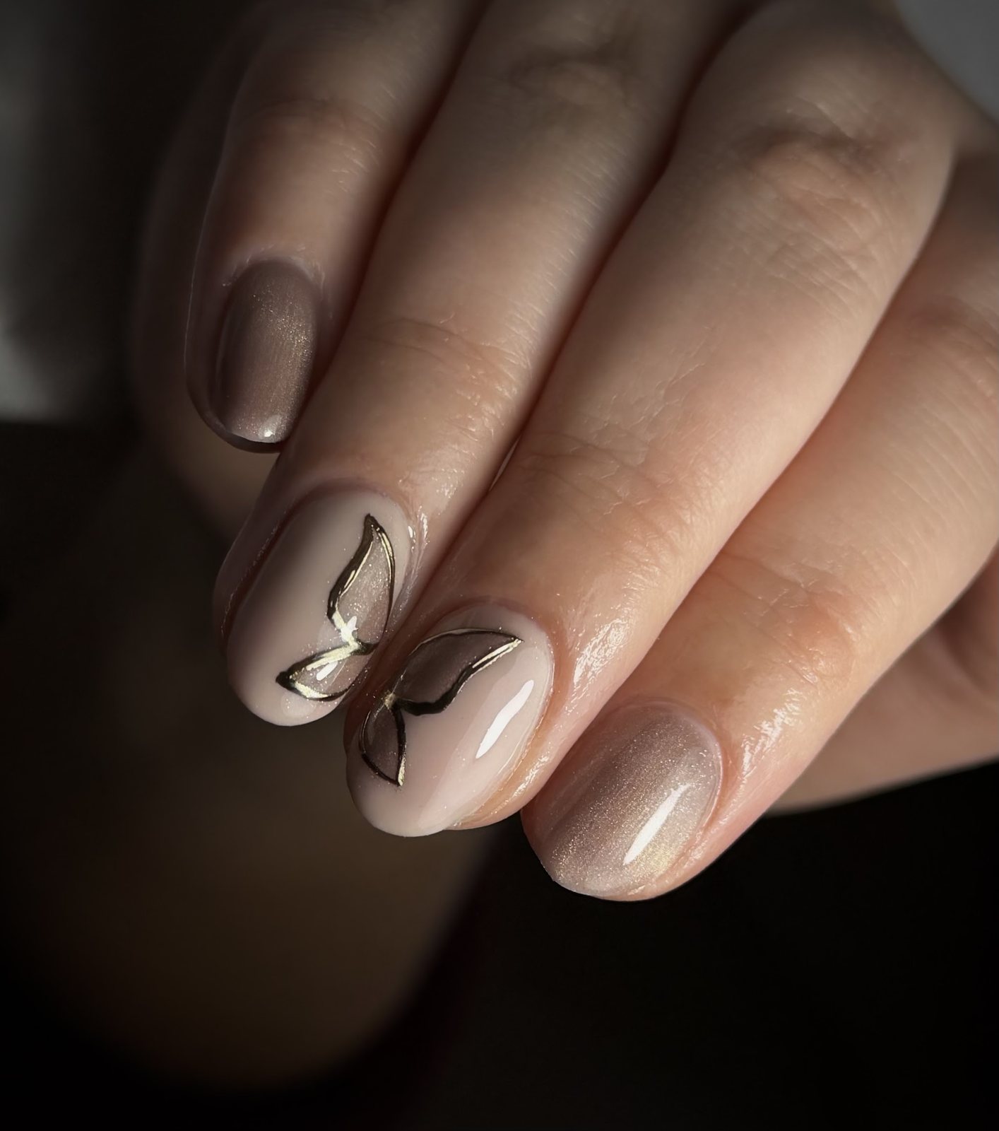 Taupe cat-eye nagels met gouden vlinderlijntjes, gezet door Studio Zoya